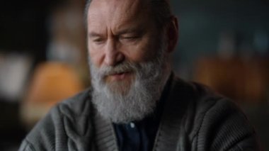 Lüks evde video görüşmesi yapan gülümseyen yaşlı adam. Yakın plan kıdemli iş adamı. 