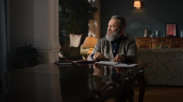 Старший бизнесмен работает с бумагами на столе в роскошном доме — стоковое видео