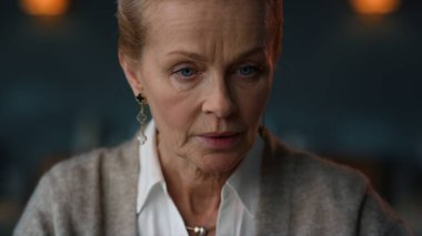 Kendinden emin yaşlı bir kadın lüks evdeki dizüstü bilgisayardan videoyu arıyor.