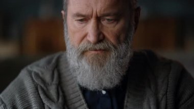 Lüks dolapta dizüstü bilgisayar kullanan yaşlı bir adam portresi