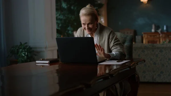 Vanhempi innoissaan nainen vastaanottaa hyviä uutisia kannettavan tietokoneen ylellisessä huoneessa — kuvapankkivalokuva