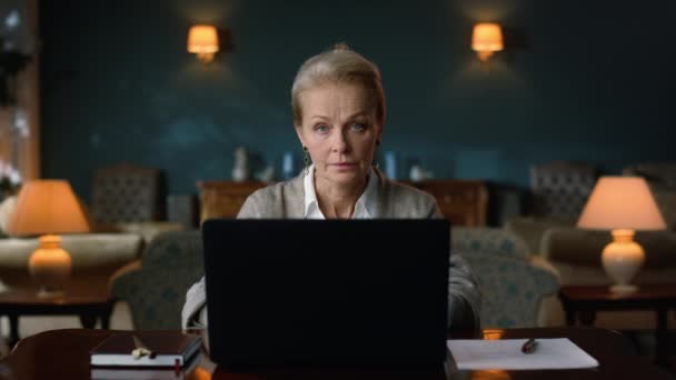 편안 한 할머니 가 집에서 노트북으로 일하고 있습니다. 아름다운 나이든 사업가의 초상화 — 비디오