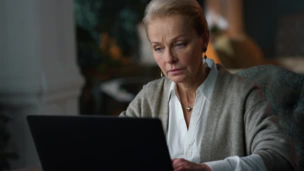 Old woman working laptop computer at home. Elderly lady looking laptop — Stock Video