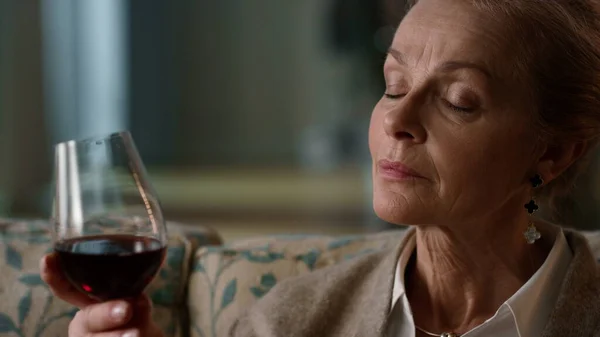Retrato calmo mulher idosa relaxante com bebida alcoólica. Senhora beber vinho de vidro — Fotografia de Stock