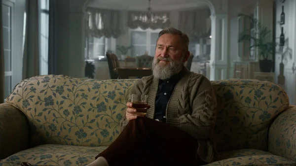 Rijke oudere man geniet van pensioen leven cognac. Zelfverzekerde oude heer die drinkt — Stockfoto