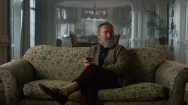 Alkol bardağıyla düşünen olgun bir adam. Zengin yaşlı büyükbaba dinleniyor