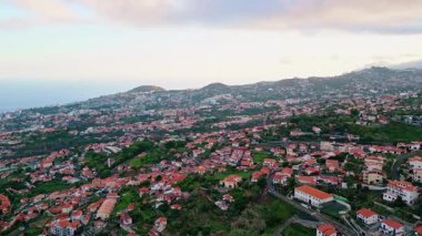 Kasvetli sahil beldesi insansız hava aracı manzarası. Resimli Orman Tepesi 'ne kurulmuş harika bir yerleşim yeri. Sakin okyanus mavi gökyüzü yavaş çekim. Güzel sahil doğası. Manzaralı seyahat kasabası