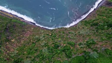 Köpüklü turkuaz deniz taşlı kayalıklara sıçrıyor. Yazın yeşil mangrov ormanlarıyla kaplı havadan görülebilen vahşi dağlar. Tehlikeli mavi göl dalgaları kayalık yarımadaları kıyıya vuruyor. 