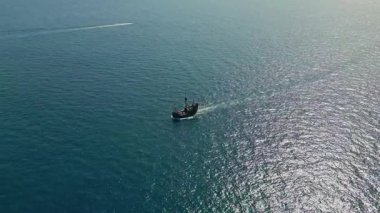 İnsansız hava aracı, yüzen denizi olan büyük ahşap bir gemi görüyor. Açık denizdeki tarihi yelkenli gemi yaz güneşini yansıtıyor. Okyanus yüzeyinde hareket eden eski bir yelkenli. Deniz yolculuğu konsepti.