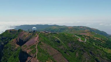 Pico do Arieiro 'daki beyaz meteorolojik radar kubbesi resimli bulutları çevreledi. Hava manzaralı dağ yolları Madeira adası. Güzel İskoçya 'daki araştırma istasyonunun panoramik manzarası.