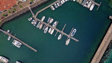 Güzel marina manzaralı lüks yatlar demirlemiş. Samimi Akdeniz kasabası yakınlarındaki Panorama sahil limanı. İnsansız hava aracı kiremitli çatı binalarıyla deniz kenarı yerleşimlerini vurdu. Deniz yolculuğu konsepti.