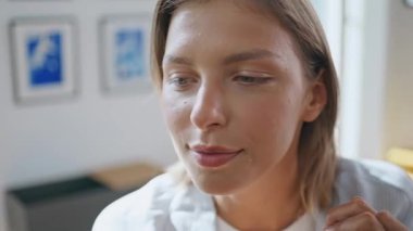 Yakından dost canlısı bir kadın gün ışığında konuşuyor. Güzel gülümseyen kız evde bilinmeyen bir arkadaşla dedikodu yapıyor. Oldukça kısa saç modeli sabah kahvesinde keyifli sohbetler yapıyor..