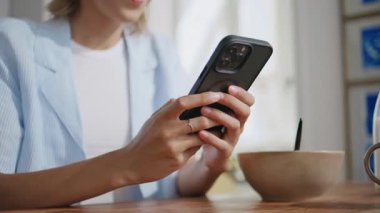 Kız elleri sabah evde cep telefonuna mesaj atıyor. Gevşemiş kullanıcı kahvaltıdan sonra internet iletişiminin tadını çıkarıyor. Hafta sonu güneşli mutfakta arkadaşlarıyla mesajlaşan tanınmamış bir kadın.