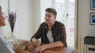 Erkek, kız arkadaşıyla sabah sohbetinden zevk alıyor. Kahvaltıda dinleme partneri olan yakın arkadaş. Rahat koca desteği ilişki tartışması. Evli çift mutfak masasında oturuyor..