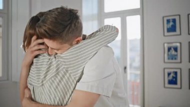 Heyecanlı yeni evliler, evlerinde kucaklaşıyorlar. Mutlu adam mutlu bir eş ile daire satın almayı kutluyor. Birlikte hayatın tadını çıkaran neşeli genç insanlar. Tasasız yaşam tarzı ilişki konsepti.