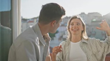 Balkonda erkek arkadaşıyla konuşan neşeli bir kız. Güneşin altında rahat insanlar şehir çatılarının manzarasına hayran mutlu sohbetin tadını çıkarıyorlar. Tasasız çift hafta sonu için seyahat planlarını tartışıyor..