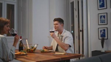 Sıcak yemek odasında şarap içen neşeli bir aile. Mutlu çift evde romantik buluşmanın tadını çıkarıyor. Gülen eşler gülerek akşam keyifli sohbetler yaparlar. Aile yaşam tarzı