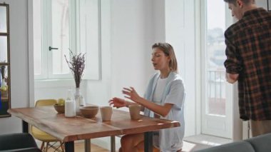 Gülümseyen koca sıcak mutfakta kahvaltı servisi yapıyor. Gençler hafta sonları birlikte sabahın tadını çıkarıyorlar. Kaygısız, sevgi dolu bir çift lezzetli yemeklerle birlikte yemek masasında oturuyor. Mutlu yeni evli çiftimiz evde..