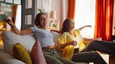 İki arkadaş kanepeye düşüp rahat atmosferin tadını çıkarıyorlar. Gülümseyen kardeşler yeni daireye taşındıktan sonra rahat koltukta dinleniyorlar. lgbtq çifti oturma odasında konuşurken mutlu olun..