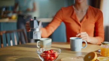 Bayan el yapımı kahve makinası kahvaltıda ablasıyla birlikte yakın plan çekimde. Rahat kadın sıcak kahveyi ahşap masaya döküyor. İki arkadaş sabah kafeinlerini birlikte içerler.