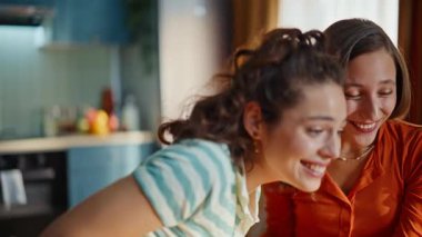 Duygusal iki kadın birbirine sarılıyor. Daire mutfağında harika e-postalar atıyorlar. Yakın plan. Heyecanlı kankalar koleje kabul ilanını birlikte kutluyorlar. Memlekette başarıyı tartışan neşeli öğrenciler gülüyor..