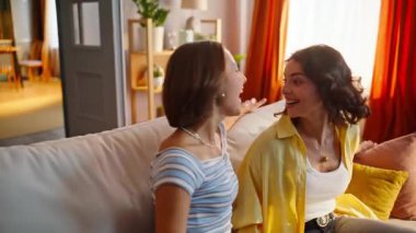 Mutlu kız kardeşler kanepeye düşüp yumuşak yastıkların keyfini çıkarıyorlar. Yeni evden taşındıktan sonra rahat koltukta oturan gülümseyen lezbiyen çift. Neşeli arkadaşlar modern oturma odasında birlikte dinleniyorlar..