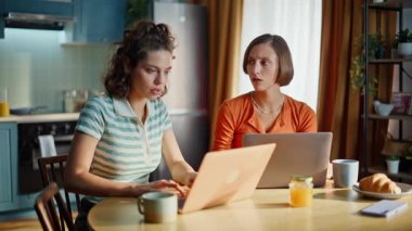 Kadınlar finansal kaybın mutfaktaki dizüstü bilgisayarları birbirine yaklaştırmasından endişeleniyor. Bilgisayarda kötü haber okuyan iki bayanın stres hissetmesi sinirlerimi bozdu. Endişeli çift öğrenci test sonuçlarını evde hayal kırıklığına uğrattı.