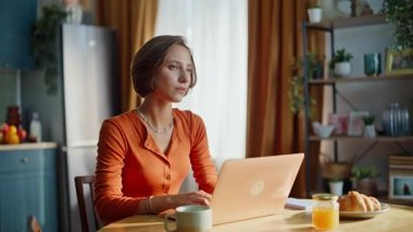 Düşünceli bir kadın ev mutfağında dizüstü bilgisayara göz atıyor. Düşünceli bayan serbest çalışan kahve içen apartman dairesindeki internet projesini düşünen. Düşüncelere dalmış sakin bir yazar kız. Kapalı alandaki fikirleri düşünüyor.