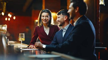 Partying people taking drinks bar counter closeup. Joyful business friends making toast raising glasses at night club. Positive colleagues enjoying meeting together indoor. Event celebration concept