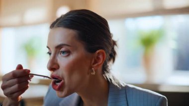 Cafe müşterisi hafif bir iç mekanda tatlı yiyor. Rahatlamış bir kadın evde tek başına yemek yiyor. Sakin bir iş kadını kafeteryada yemeğin tadını tek başına alıyor.