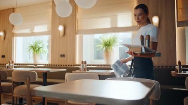 Boş kafede sakin bir garson masasını temizliyor. Ciddi restoran personeli sabahları tek başına çalışan bezlerle yüzey siliyor. Genç servis görevlisi müşteriler için kafeterya hazırlıyor.
