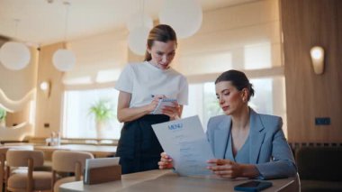 Restoran misafiri konuşuyor, garsonlar menü okuyor, siparişleri kapatıyorlar. Kafeteryada güzel kadın ziyaretçilere hizmet eden beyaz tişört giyen tatlı kız şeyleri. İş kadını rahat bir kafe masasında sakince oturuyor.