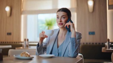 Samimi kafeterya masasında oturan kendine güvenen bir bayan konuşuyor. Cafe 'de kahve molasında cep telefonuyla konuşan güzel bir iş kadını. Zarif bir kadın lokantada dinleniyor.