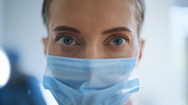 Pov video maskeli hekim hasta muayenesini modern klinikte tamamlıyor. Birinci şahıs görüşü. Hafif hastanenin yakın çekimlerinde doktor kadının portresi. Sağlık ve Tıp Konsepti