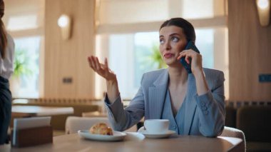 Yakından rahatlamış bir kadın, rahat kafeteryada akıllı telefonu arıyor. Duygusal iş kadını kafedeki cep telefonuyla tatmin edici haberler alıyor. Lokantada cep telefonuyla konuşan güzel esmer kadın.