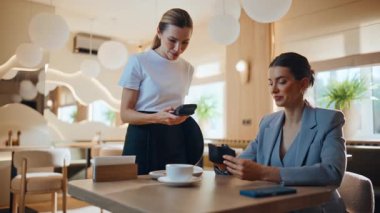 Gülümseyen kadın, restoran ışıklarının altında kredi kartıyla hesabı kapatıyor. Kendine güvenen bir kadın akşam yemeğinden zevk alıyor ve kafede nakit ödeme yapıyor. Zarif iş kadını yemekten sonra garsonla konuşuyor.