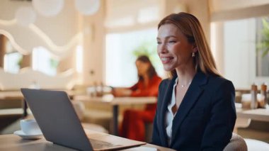 İş kadını, hafif kafe içerisindeki internet kamerasına işaret eden video toplantısını yönetiyor. Zarif kadın danışman çevrimiçi arıyor. İnternet konferansında gülümseyen müdür kafeteryada konuşuyor..