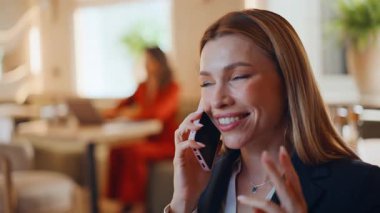 Kız rahat kafeteryada cep telefonu sohbetinden zevk alıyor. Modern restoranda cep telefonunu arayan mutlu iş kadını portresi. Gülümseyen kadın yöneticinin hoş bir akıllı telefon iletişimi var.