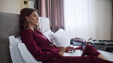 Zarif bir bayan dizüstü bilgisayarı kapatıyor rahat bir yatak odası kapanıyor. Gülümseyen iş kadını internet işini bitirdiğinde otel odasına iş gezisine geliyor. Şık giyinen şık bir kadın yatakta dinleniyor..