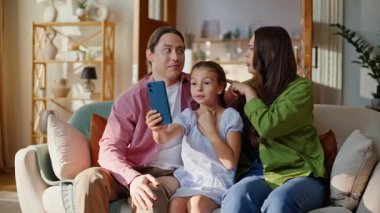 Gülücükler saçan insanlar güneş ışığıyla çevrimiçi akıllı telefonları arıyorlar. Mutlu kadın ve kız, rahat bir dairede cep telefonu ekranına bakıyorlar. Aile, evin içinde görüntülü konuşma yapıyor.