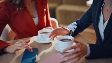 İş arkadaşlarım, sıcak restoranda kahve molası veriyoruz. Ahşap masa kafeteryasında üzerinde akıllı telefonlar olan espresso bardakları. Arkadaşça bir toplantıda gülümseyen kadın iş arkadaşları. Rahatlama toplantısı.