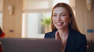 Modern kafeteryadaki çevrimiçi yönetici videosu. Lokantada dizüstü bilgisayar arayan zarif bir iş kadını. İnternet sohbetinde konuşan mutlu kadın danışman, açık kafede oturuyor..