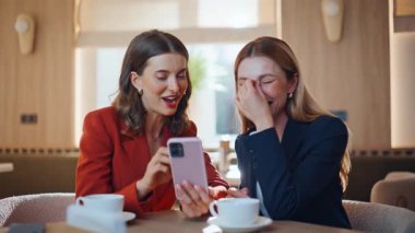 Cep telefonuyla internetten satış yapan bir kadın, tatilde en iyi arkadaşa rahat bir kafeteryada otururken görülüyor. İki pozitif meslektaşım kafede cep telefonuyla sosyal medyayı tartışıyor. Gülümseyen zarif bayanlar konuşuyor..