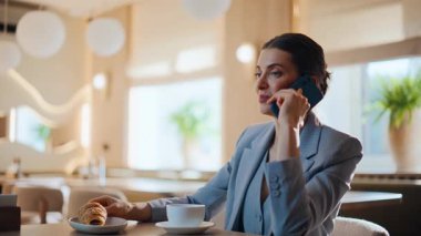 İş kadını cep telefonuyla konuşan kafeteryayı kapatıyor. Açık kafede kadın akıllı telefon görüşmeleri. Neşeli kadın çağırıyor