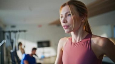 Günlük spor salonunda su içen koşu kadını yakın plan. Gülümseyen sporcu kadın yoğun kardiyo eğitiminde ferahlatıcı. Spor kulübünde koşu bandında koşan enerjik bir bayan. Sıvı dengesini sağlayan kız.