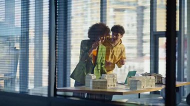 Müteahhitler mühendislik şirketinde cep telefonlarını konuşmakla meşguller. Profesyonel çok ırklı mimarlar bina projesini tartışmak için arıyorlar. İnşaatta beyin fırtınası yapan iki iş arkadaşı.