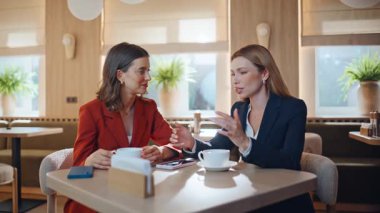İki meslektaş kafe ile buluşuyor. Dostça iletişimin keyfini çıkarıyorlar. Birlikte oturan iş arkadaşına akıllı telefon ekranı gösteren zarif bir kadın. Birkaç arkadaş cep telefonunun fotoğrafını tartışıyor..