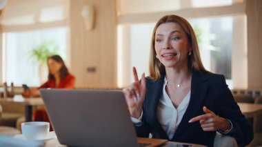CEO, internetteki pazarlıkta konuşuyor. Kafede dizüstü bilgisayara bakıyor. Gülümseyen iş kadını restorandaki internet konferansında projeyi tartışıyor. Kafeteryadaki zarif serbest oyuncu videosu..