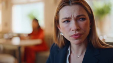 İş kadını rahat bir kafe 'de oturup şık bir takım elbise giyerek başarısızlıktan endişeleniyor. Portre, iş kadınının iş problemleri üzerine düşündüğünü vurguladı. Duygusal çöküntüye uğramış kadın şakaklara dokunuyor krizle ilgili.