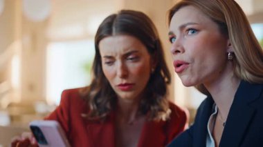 Endişeli meslektaşlarım kafeteryada cep telefonu mesajlarını okuyorlar. İki iş kadını kafeteryada akıllı telefon ihbarında sinirlendi. Hayal kırıklığına uğramış ortaklar cep telefonuyla kötü haber alıyorlar.